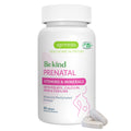 A white bottle of Igennus Be Kind Prenatal vitamins and minerals with three light gray tablets in front, on a solid white background.
