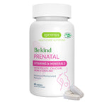A white bottle of Igennus Be Kind Prenatal vitamins and minerals with three light gray tablets in front, on a solid white background.