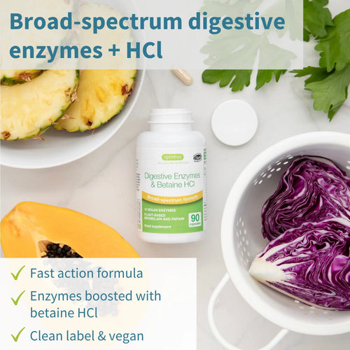 Bottle of digestive enzymes with pineapple, cabbage, and other ingredients on a white background